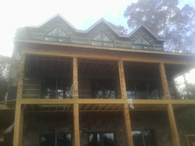 Dormers and porch framing on a large log home under construction — Roof Coating work by our crew in Spindale