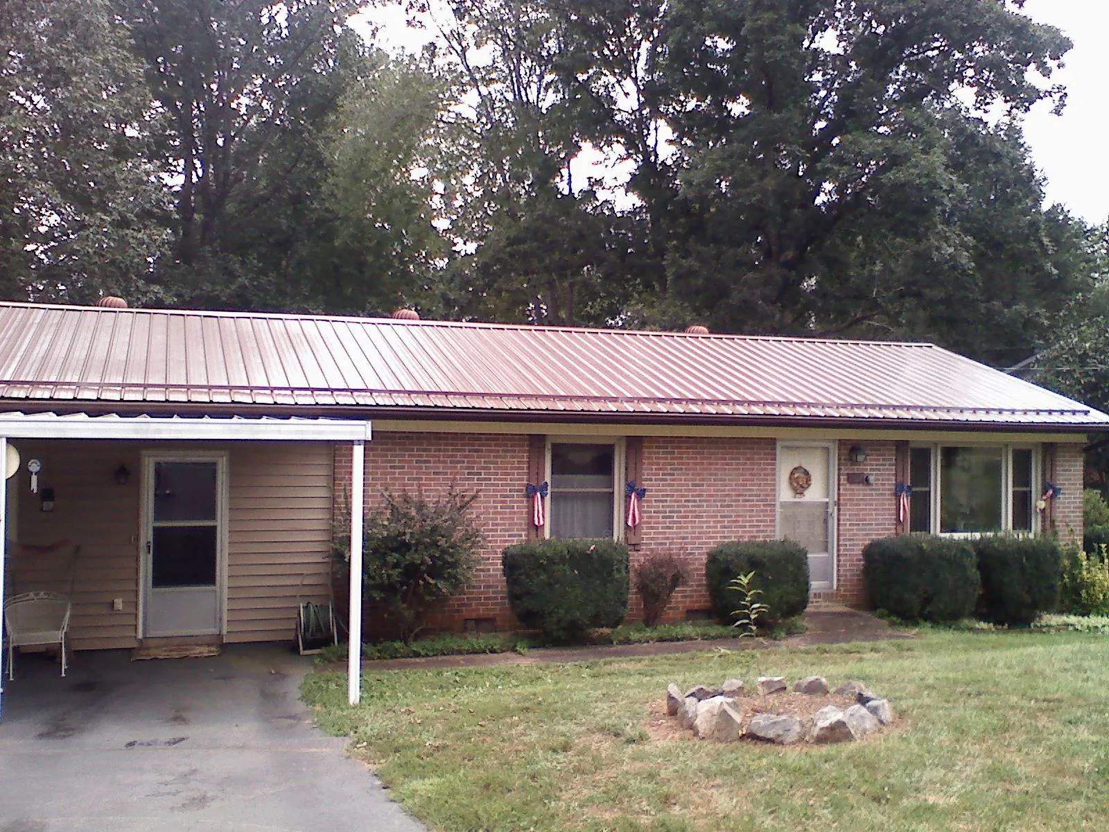 Bronze metal roof and carport on a brick ranch home — Roof Repair work by our crew in Spindale