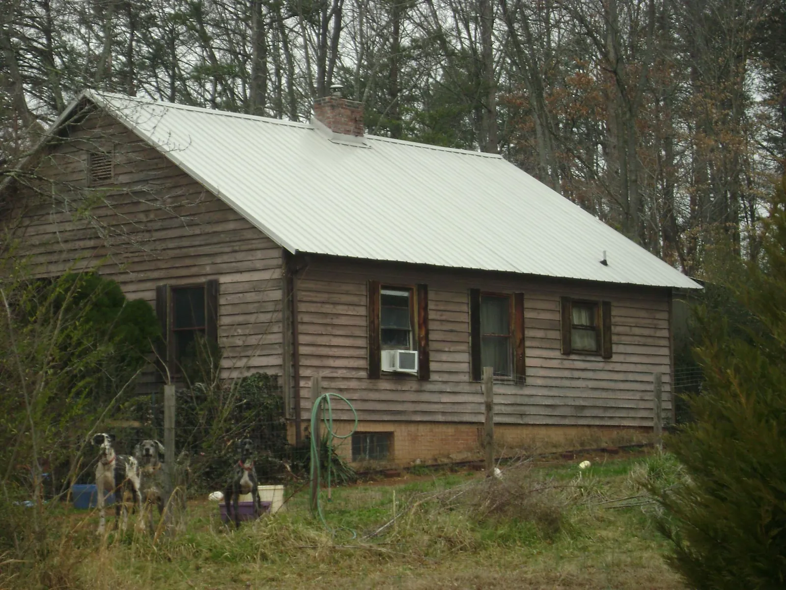 White metal roof on an old wood sided farmhouse, from a Metal Roof Installation job in Spindale